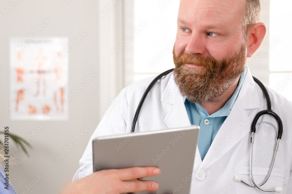 Doctors discussing report about a patient at tablet computer in hospital Doctors discussing report about a patient at tablet computer in hospital