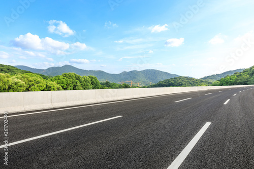 Empty asphalt road and mountains with blue sky on a sunny day