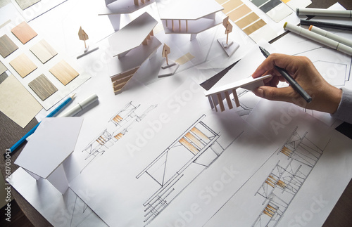 architect design working drawing sketch plans blueprints and making architectural construction model in architect studio