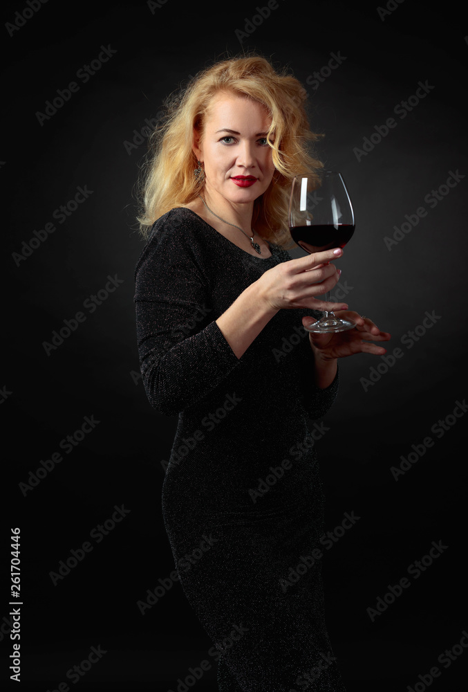 Attractive woman in black evening dress with glass of red wine. Attractive woman in black evening dress with glass of red wine.