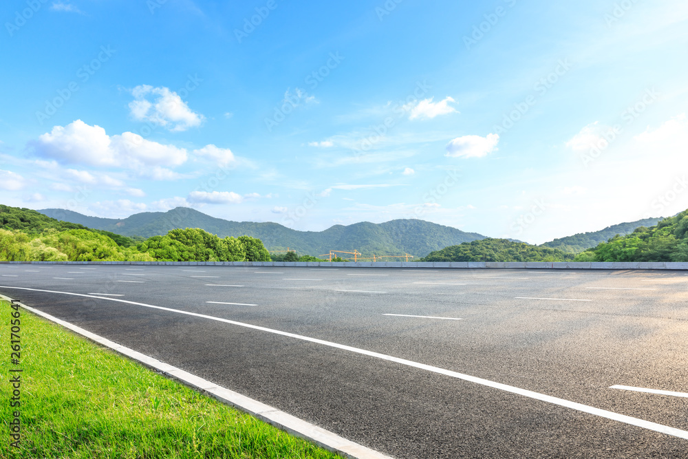 Fototapeta premium Empty asphalt road and mountains with blue sky on a sunny day