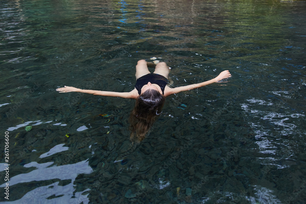 A young girl swims in the pool.