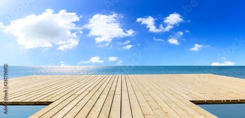 Wooden floor platform and blue sea with sky background