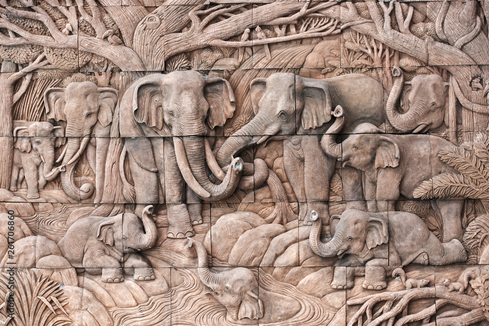 Naklejka premium Elephant carved in stone on the temple wall in Thailand
