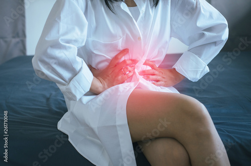 Woman having painful stomachache and suffering from abdominal pain,Period cramps,Hands squeezing belly photo