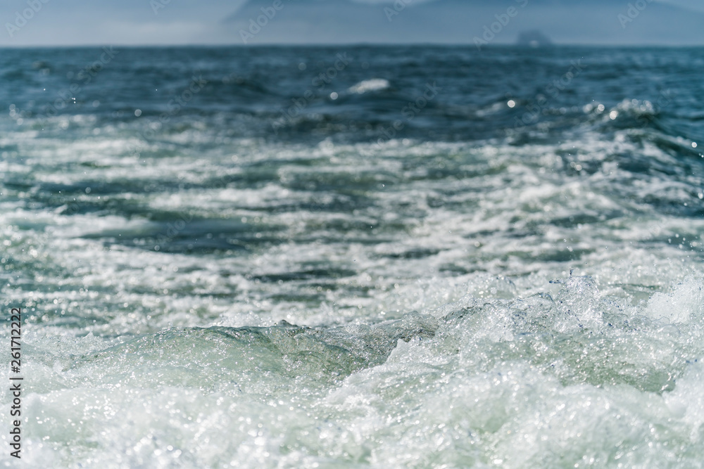 A deep blue sea with island in distance with medium water wave ripple. A deep blue sea with island in distance with medium water wave ripple.