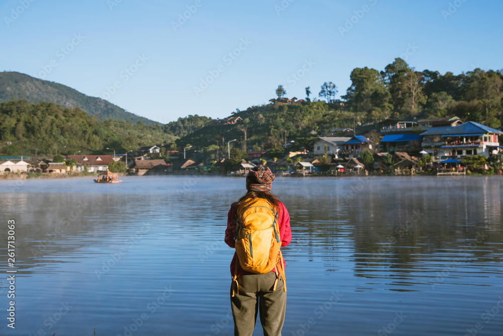 Fototapeta premium The woman standing near the lake, she was smiling, enjoying and enjoying the natural beauty of the mist.