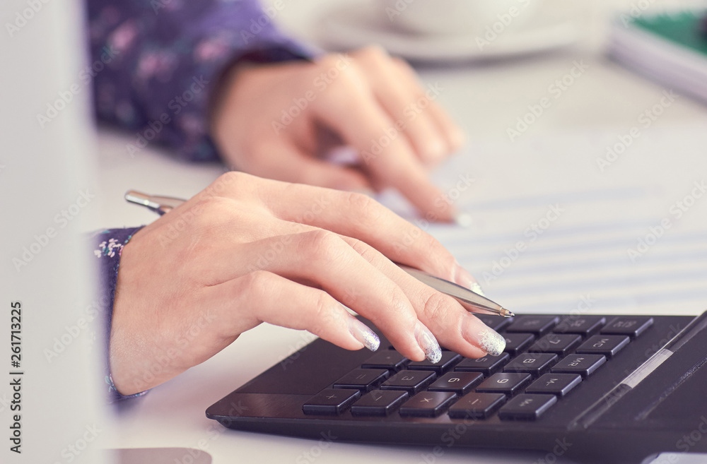Close up of female accountant or banker hand making calculations. Savings, finances and economy concept Close up of female accountant or banker hand making calculations. Savings, finances and economy concept