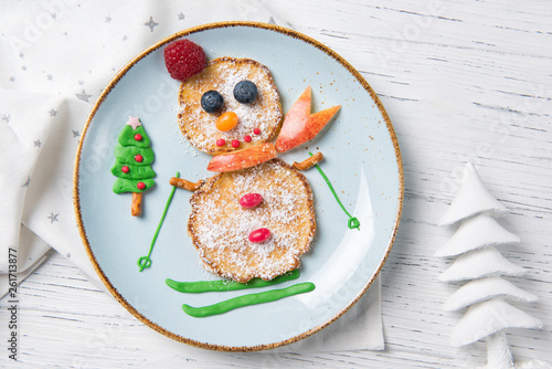 Pancakes in the shape of snowman on ski, Christmas breakfast for kids idea, top view