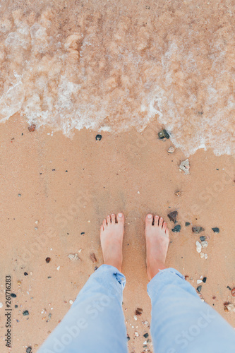 Woman tanned legs on sand beach