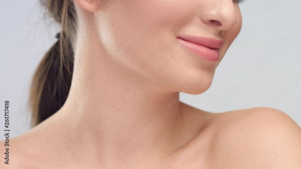Young woman with smooth healthy skin smiles on grey background Young woman with smooth healthy skin smiles on grey background