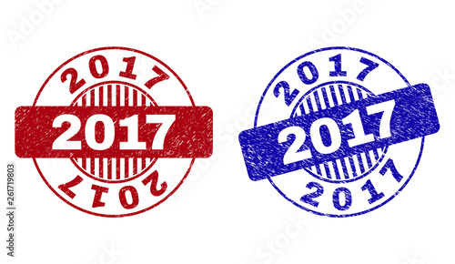 Grunge 2017 round stamp seals isolated on a white background. Round seals with grunge texture in red and blue colors. Vector rubber imprint of 2017 text inside circle form with stripes.