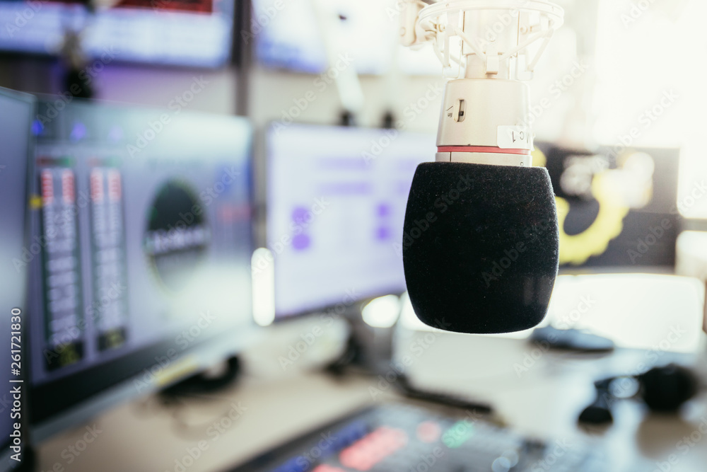 Radio broadcasting studio: Microphone in the foreground, modern studio in the blurry background