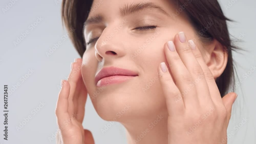 Young woman with healthy smooth skin gently stroking her face Young woman with healthy smooth skin gently stroking her face