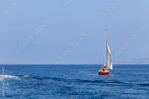 A yacht floating in the sea, red sailboat. Holidays, active lifestyle.