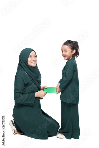 Malay mother giving money packet to daughter during festive celebration