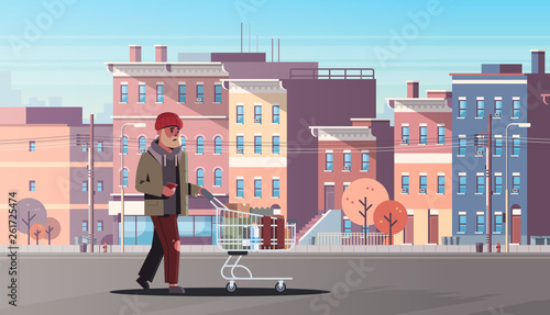 poor man pushing trolley cart with belongings beggar guy walking street begging for help homeless concept modern city buildings cityscape background horizontal full length
