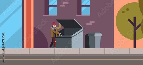 poor man looking for food and clothes in trash can outdoor homeless jobless concept city street building exterior background horizontal full length