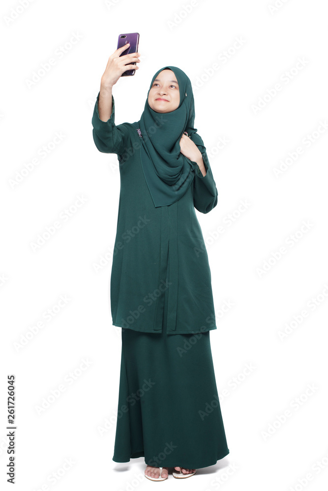 Malay woman taking selfie using smartphone Malay woman taking selfie using smartphone