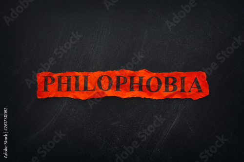 Word Philophobia on red torn piece of paper