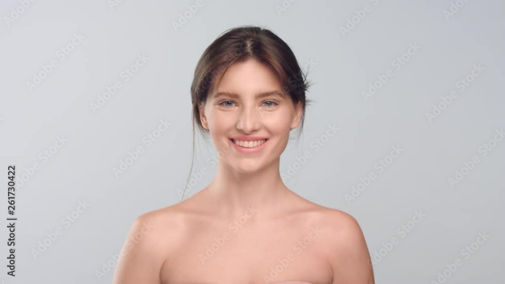 Woman with smooth skin standing in front of camera and smiling Woman with smooth skin standing in front of camera and smiling