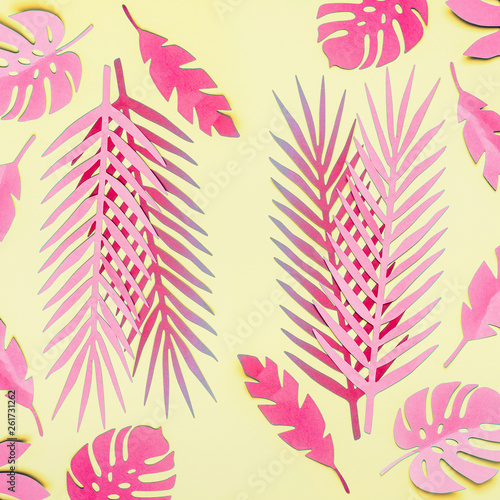 Pink tropical leaves flat lay on yellow background. Creative layout. Various tropical leaves composing