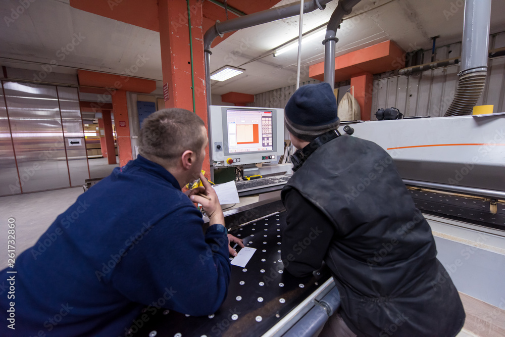 carpenters calculating and programming a cnc wood working machine carpenters calculating and programming a cnc wood working machine