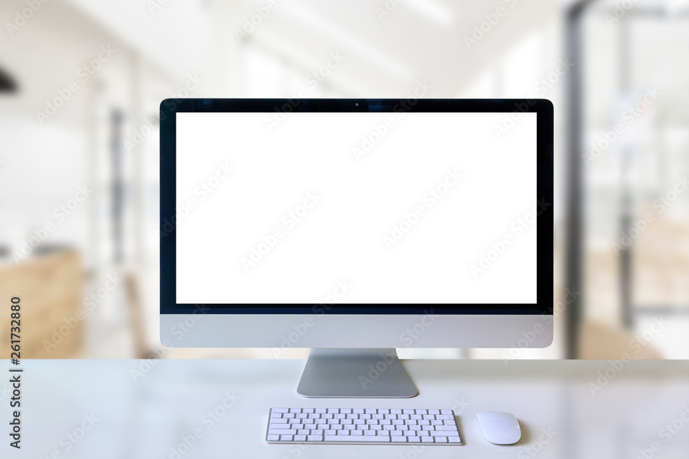 Mockup modern desktop computer with blank white screen on white wooden table in co-workspace room. Mockup modern desktop computer with blank white screen on white wooden table in co-workspace room.