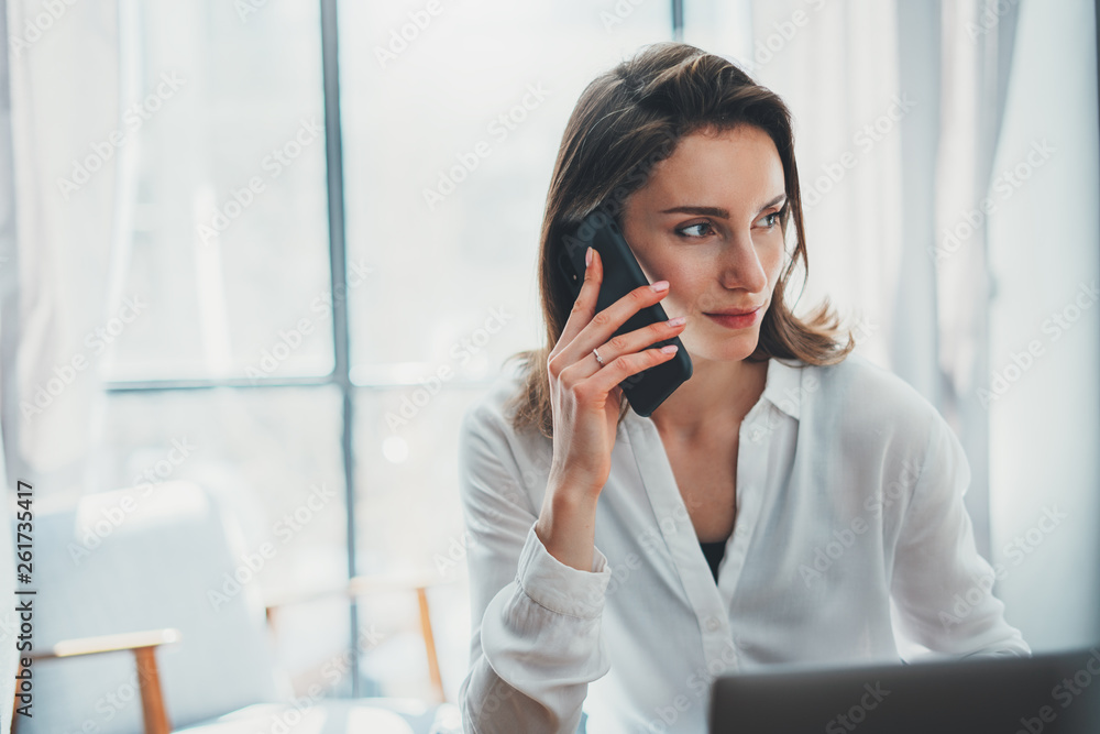 Business woman using mobile phone at working day in office.Blurred background. Business Technology Communications Mobility Business woman using mobile phone at working day in office.Blurred background. Business Technology Communications Mobility