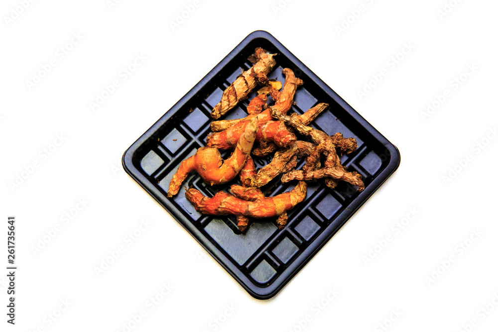 The expired turmeric root on black plastic plate that bought from supermarket The expired turmeric root on black plastic plate that bought from supermarket