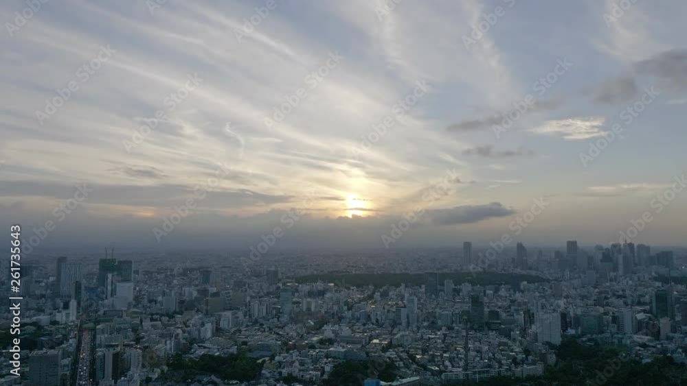 panoramic aerial pan down wide shot of tokyo city on a sunny cloudy day near sunset time. vast scenery of buildings in hazy fog and a calm sky filled with cirrus and cumulus clouds on early evening. panoramic aerial pan down wide shot of tokyo city on a sunny cloudy day near sunset time. vast scenery of buildings in hazy fog and a calm sky filled with cirrus and cumulus clouds on early evening.