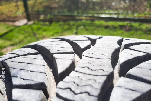 Close-up winter tire tread. Textured tire tread on green and bokeh background. photo