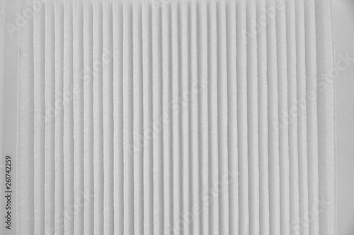 Close-up on a car filter for a white engine as a background with vertical stripes. Spare parts for vehicles, repairs and maintenance.
