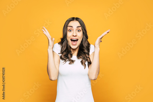 Fotografie Heyday! Surprised girl with long dark hair and stunning smile full of pleasant emotions what is seen from her body language