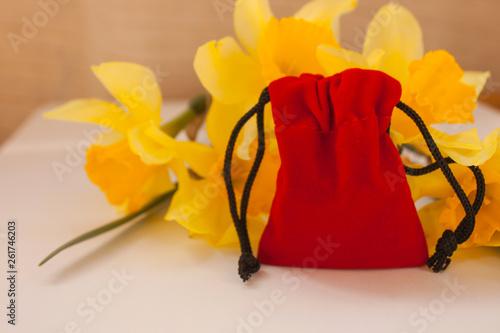 Red velvet pouch with yellow flowers on a white background, copy space photo