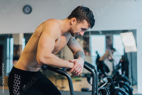 Athletic man resting after workout on cycling machine