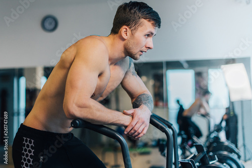Athletic man resting after workout on cycling machine
