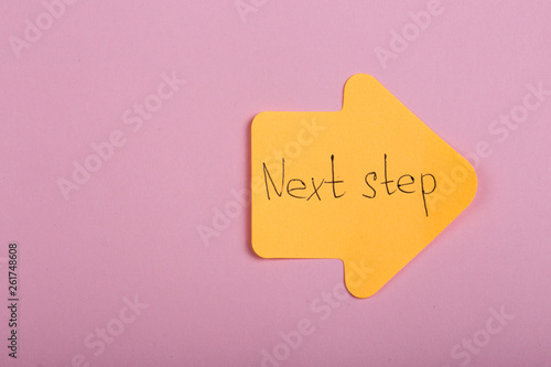 Business, future and motivation concept - orange sticker in the shape of an arrow and text 