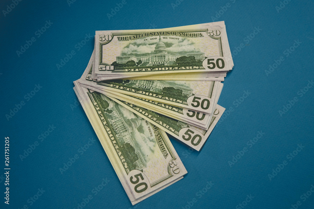 wrist watch on dollars on blue background close up wrist watch on dollars on blue background close up