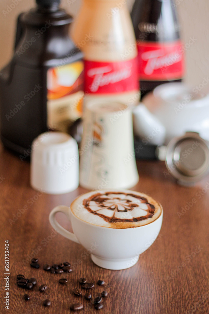 Coffee latte with beautiful design on top, coffee beans background Coffee latte with beautiful design on top, coffee beans background