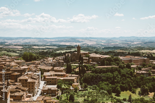 Panoramic view of Siena city with historic buildings and far away green fields