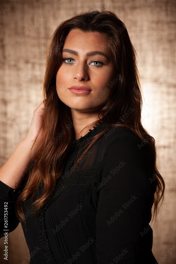 Fototapeta premium BBeauty portrait of cute brunette woman with blue eyes over grunge brown background