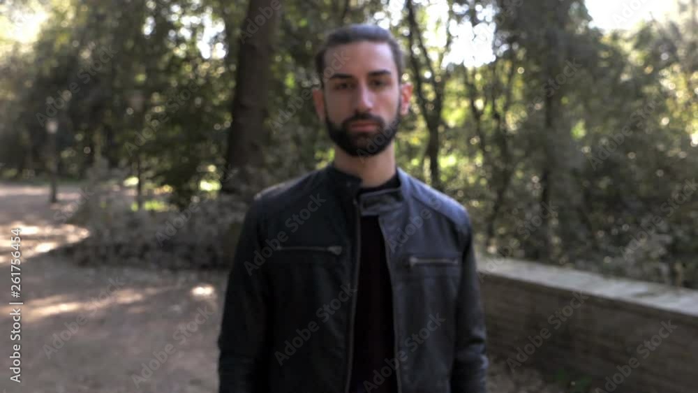 Defocused handsome young bearded man staring at camera in the park.steady cam Defocused handsome young bearded man staring at camera in the park.steady cam