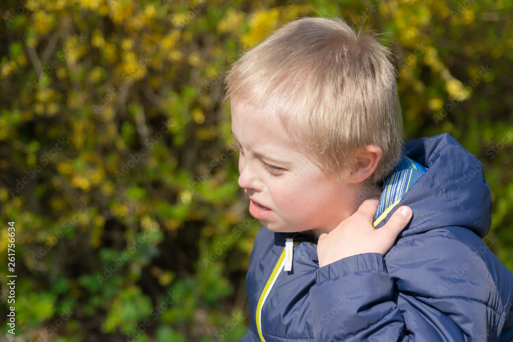 Defect,childcare,medicine and people concept: Blond boy with down syndrome playing in a park at spring time. Defect,childcare,medicine and people concept: Blond boy with down syndrome playing in a park at spring time.