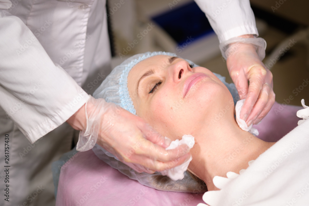 Cosmetologist remove a face mask to her patient . Anti-ageing and smoothing procedure in a beauty salon. Doctor in a cosmetological clinic making a treatment of skin care Cosmetologist remove a face mask to her patient . Anti-ageing and smoothing procedure in a beauty salon. Doctor in a cosmetological clinic making a treatment of skin care
