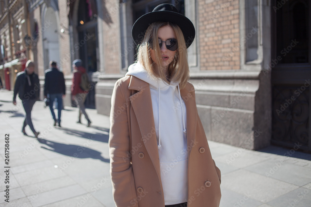 Fototapeta premium Charming young blonde on a walk. Young beautiful woman in stylish look