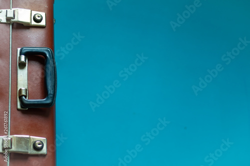 Suitcase brown old retro for travel and business. Case stands on the edge, you can see the locks and handle. Blue, aquamarine background. Copy space © Natal.is