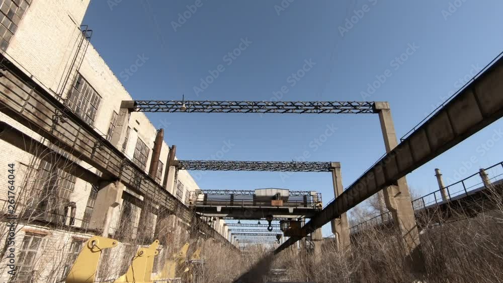 Workshops of the old factory. Large heavy bridge crane. Metal construction against the blue sky. Workshops of the old factory. Large heavy bridge crane. Metal construction against the blue sky.