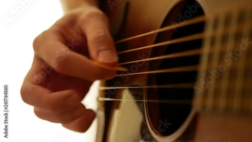 Detail of guitar picking technique (alternate picking and strumming) on a dark wood acoustic guitar