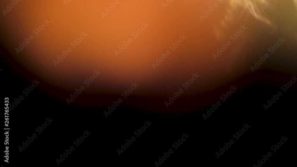Golden globe of light appears and moves over a dark background. Abstract warm bulb of light. Golden globe of light appears and moves over a dark background. Abstract warm bulb of light.
